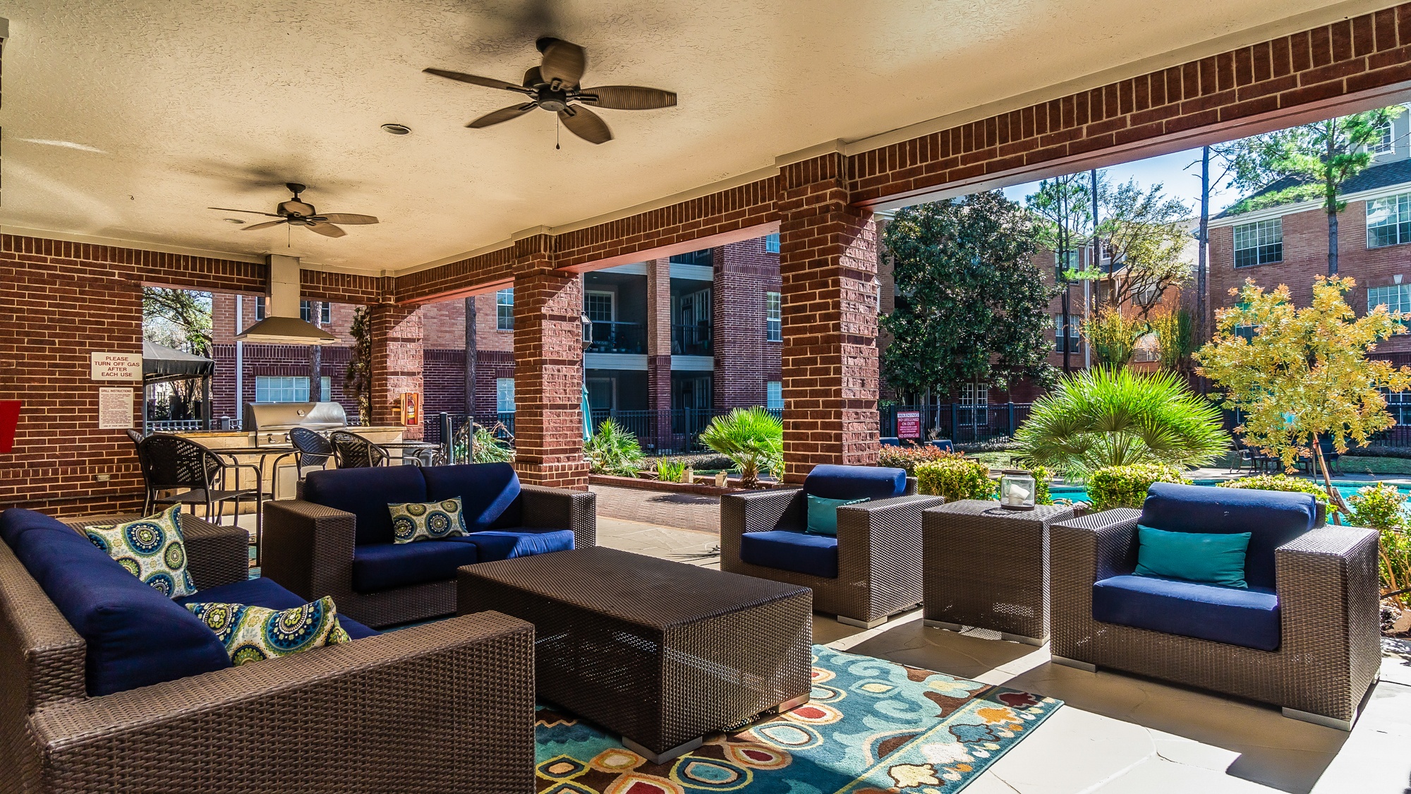A patio with a wicker sofa and chairs.